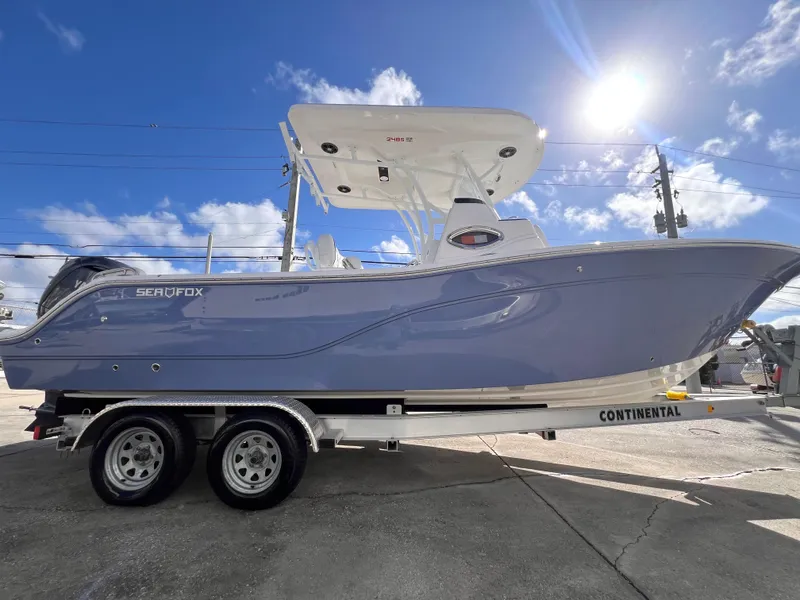 Slide: The Image of 2025 Sea Fox 248 Side Console boat on trailer under clear blue sky. - 9