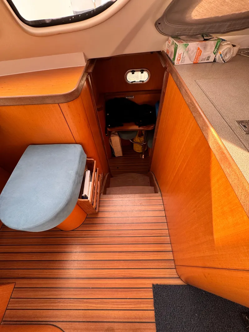 Slide: The Image of Interior of 2003 Catana 431 sailboat with wooden stairs and seating area. - 17