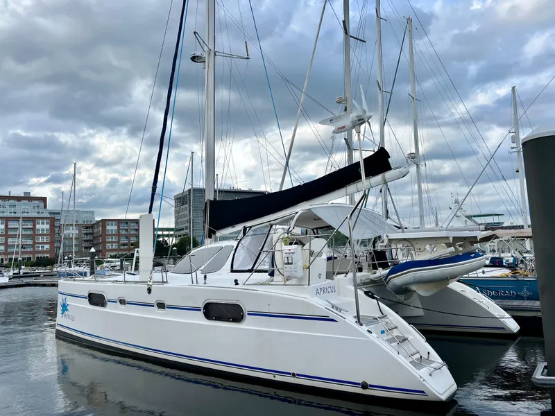 Slide: The Image of 2003 Catana 431 catamaran docked at a marina under cloudy skies. - 2