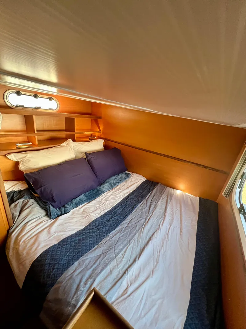 Slide: The Image of Cozy bedroom in 2003 Catana 431 yacht with plush bedding and wooden shelves. - 22
