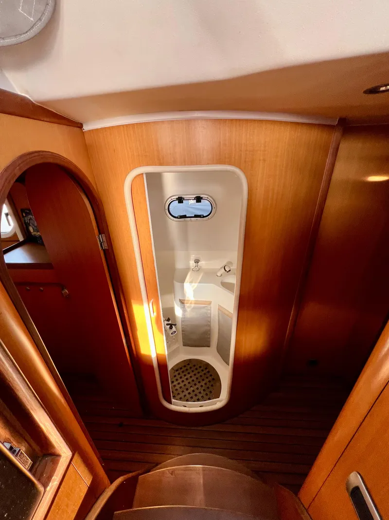 Slide: The Image of Interior of 2003 Catana 431 yacht, featuring a compact shower with wooden accents. - 25