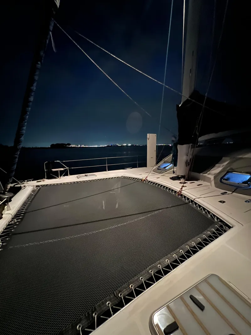 Slide: The Image of Catana 431 catamaran deck at night, 2003 model, with city lights in the background. - 31
