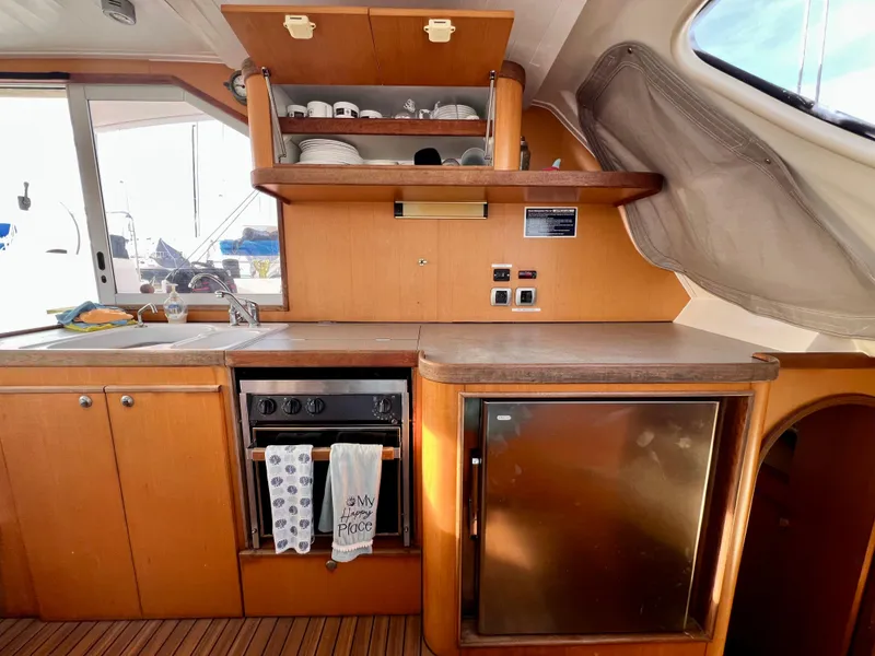Slide: The Image of Interior of a 2003 Catana 431 yacht kitchen with wooden cabinets and appliances. - 35