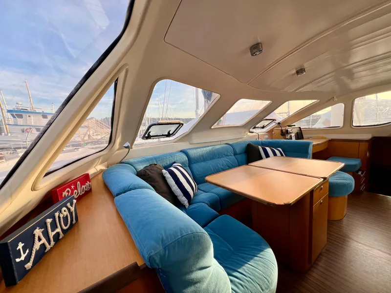 Slide: The Image of Interior of 2003 Catana 431 yacht with blue seating and wooden table. - 38