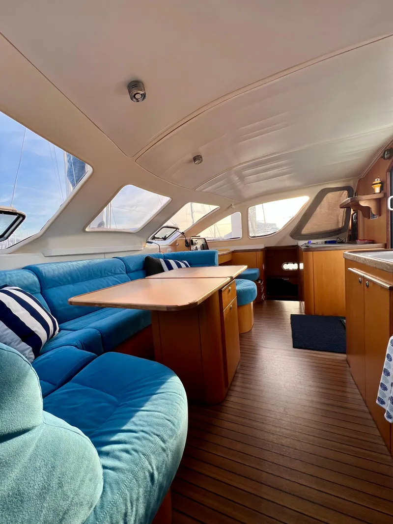 Slide: The Image of Interior of 2003 Catana 431 yacht with blue seating and wooden accents. - 39