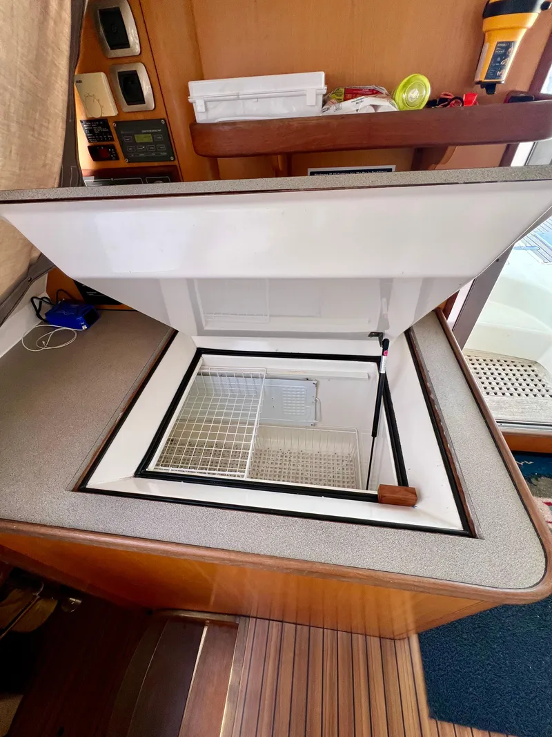 Slide: The Image of Open storage compartment on 2003 Catana 431 yacht interior, featuring wooden flooring and control panels. - 41