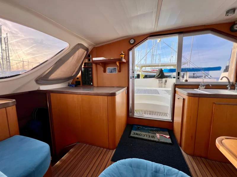Slide: The Image of Interior of 2003 Catana 431 catamaran with wooden cabinetry and marina view. - 42