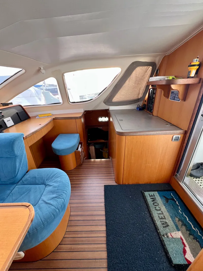 Slide: The Image of Interior of 2003 Catana 431 yacht with blue seating and wooden furnishings. - 43