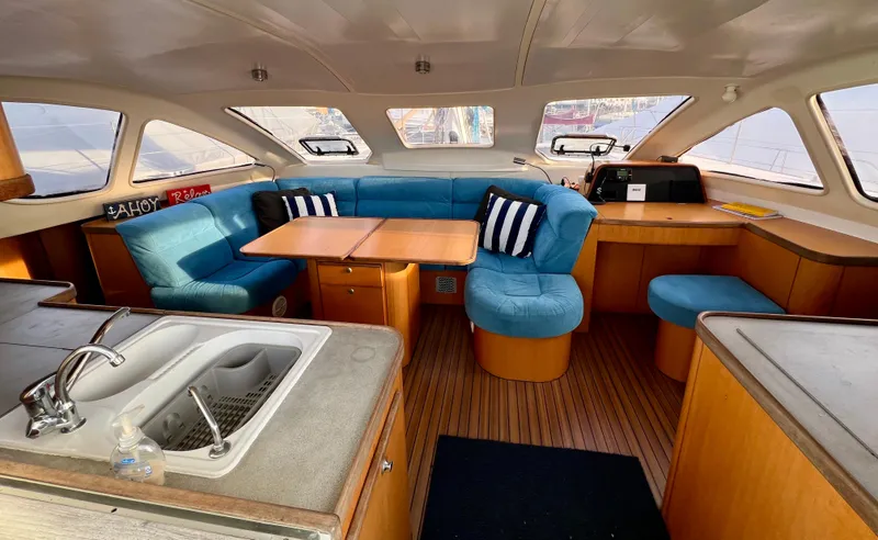 Slide: The Image of Interior of 2003 Catana 431 yacht with blue seating, wooden table, and kitchenette. - 45