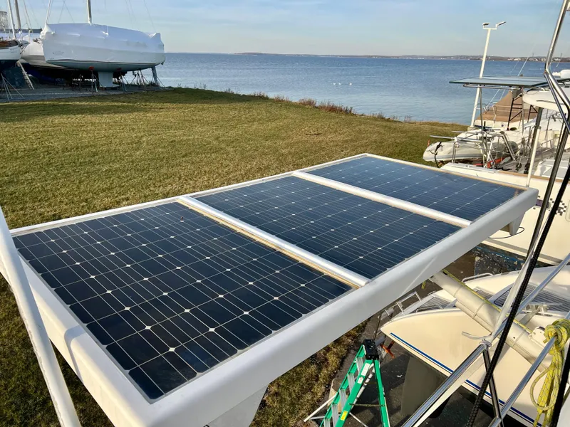Slide: The Image of Solar panels on a 2003 Catana 431 catamaran, docked near a scenic waterfront. - 46