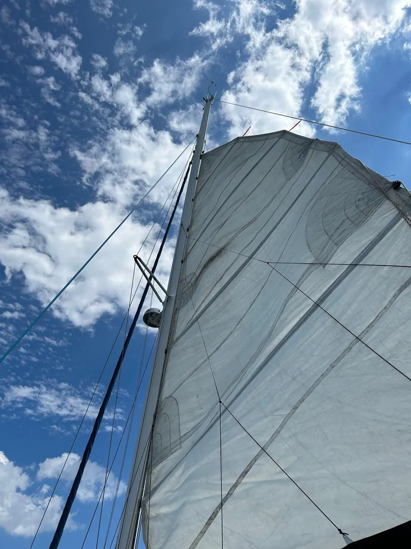 Slide: The Image of Sail of a 2003 Catana 431 catamaran against a blue sky with clouds. - 8