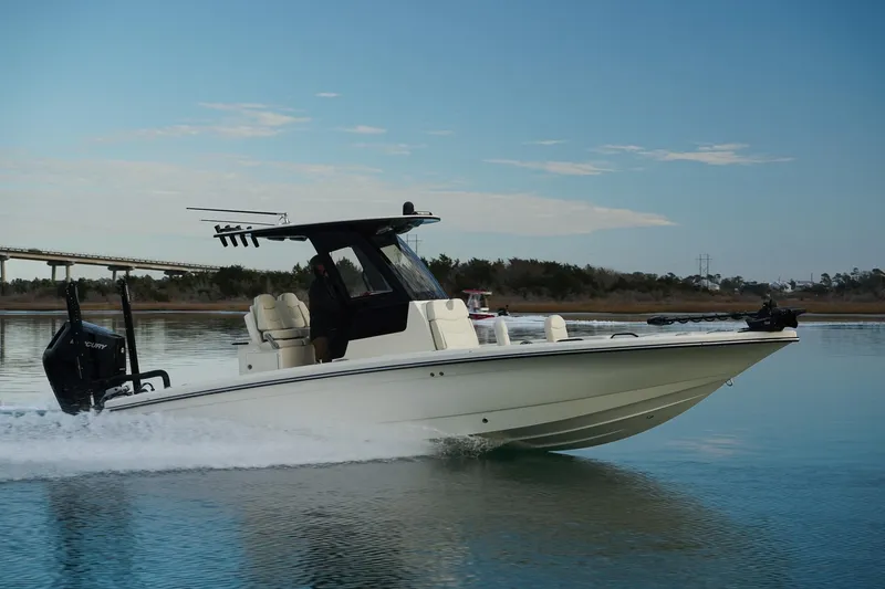 Slide: The Image of 2025 Scout 261 XSS boat cruising on calm water under a clear sky. - 13