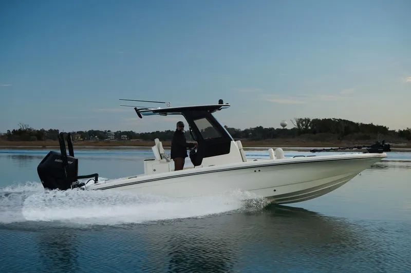 Slide: The Image of 2025 Scout 261 XSS boat cruising on calm water, side view. - 14
