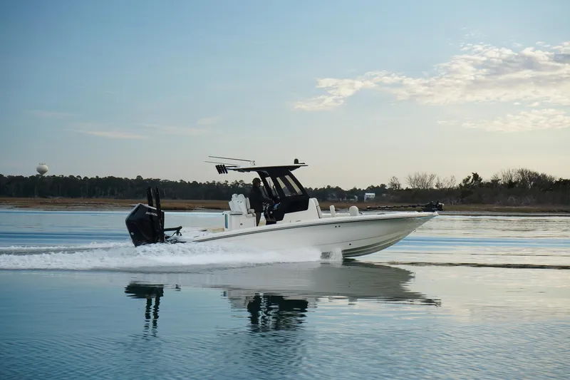 Slide: The Image of 2025 Scout 261 XSS boat cruising on calm water under a clear sky. - 16
