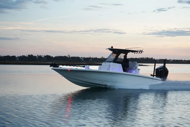 Slide: The Image of 2025 Scout 261 XSS boat cruising on calm water at sunset. - 22