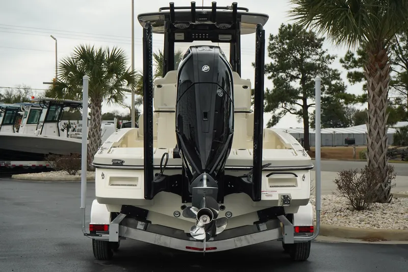 Slide: The Image of 2025 Scout 261 XSS boat on trailer, rear view, parked near palm trees. - 26