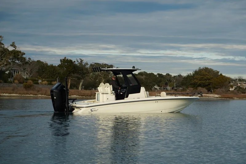 Slide: The Image of 2025 Scout 261 XSS boat on calm water, scenic background. - 3