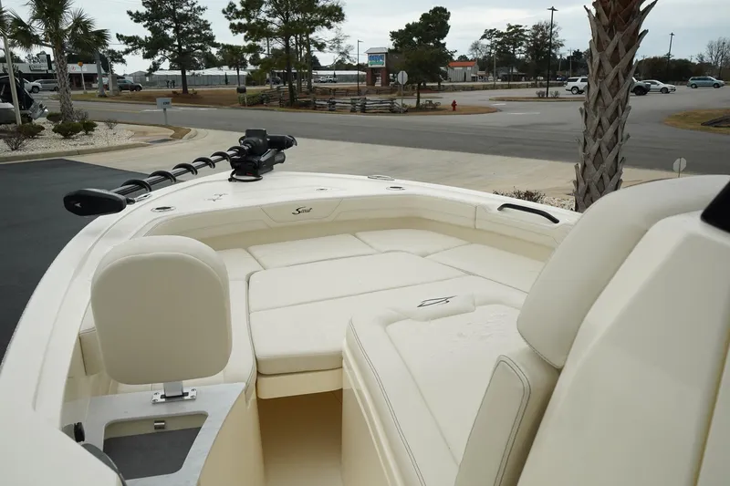 Slide: The Image of 2025 Scout 261 XSS boat interior with seating and steering, parked outdoors. - 37
