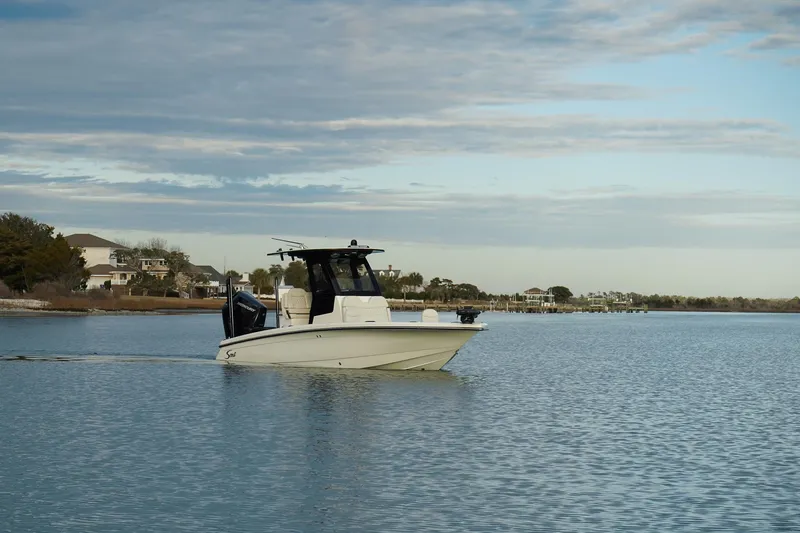 Slide: The Image of 2025 Scout 261 XSS boat cruising on calm waters under a cloudy sky. - 4