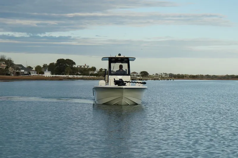 Slide: The Image of 2025 Scout 261 XSS boat cruising on calm water under a cloudy sky. - 5