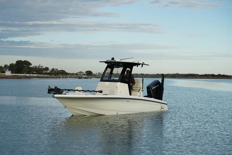 Slide: The Image of 2025 Scout 261 XSS boat on calm water under a cloudy sky. - 6