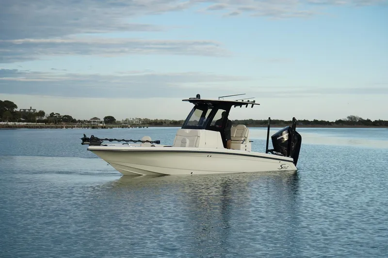 Slide: The Image of 2025 Scout 261 XSS boat on calm water under a partly cloudy sky. - 7