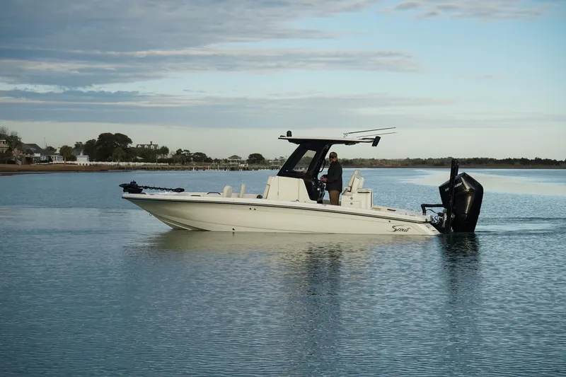 Slide: The Image of 2025 Scout 261 XSS boat cruising on calm water under a cloudy sky. - 8
