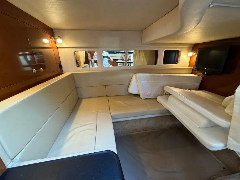 Slide: The Image of 2008 Sea Ray 310 Sundancer cabin interior with beige seating and ambient lighting. - 10