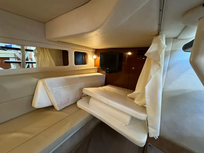 Slide: The Image of 2008 Sea Ray 310 Sundancer cabin interior with beige seating and a small TV. - 11