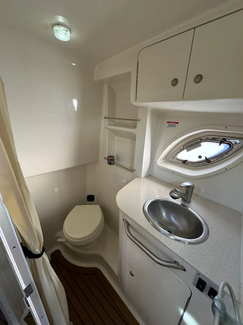 Slide: The Image of 2008 Sea Ray 310 Sundancer bathroom with sink, toilet, and porthole window. - 14