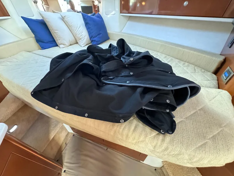 Slide: The Image of Interior of 2008 Sea Ray 310 Sundancer with cushions and black cover. - 16