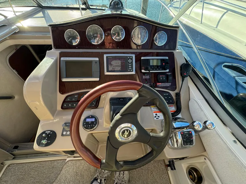 Slide: The Image of 2008 Sea Ray 310 Sundancer helm with gauges, steering wheel, and navigation controls. - 17