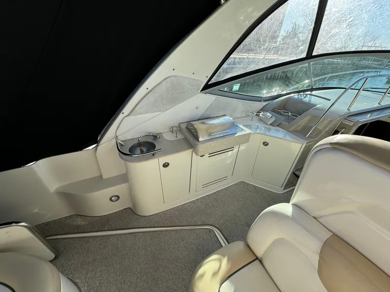 Slide: The Image of 2008 Sea Ray 310 Sundancer interior with kitchenette and seating area. - 23