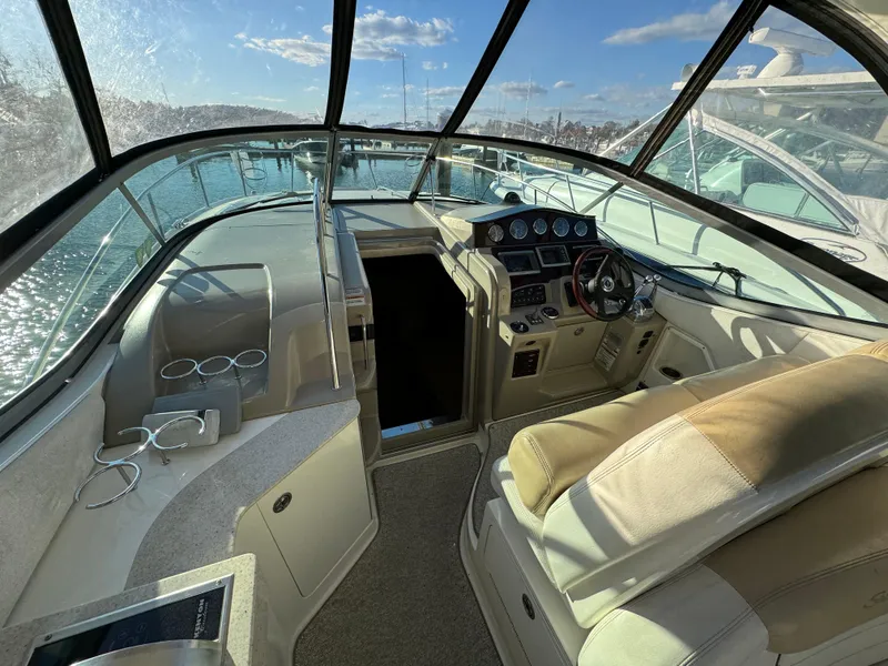 Slide: The Image of 2008 Sea Ray 310 Sundancer cockpit with helm, seating, and panoramic windows. - 26