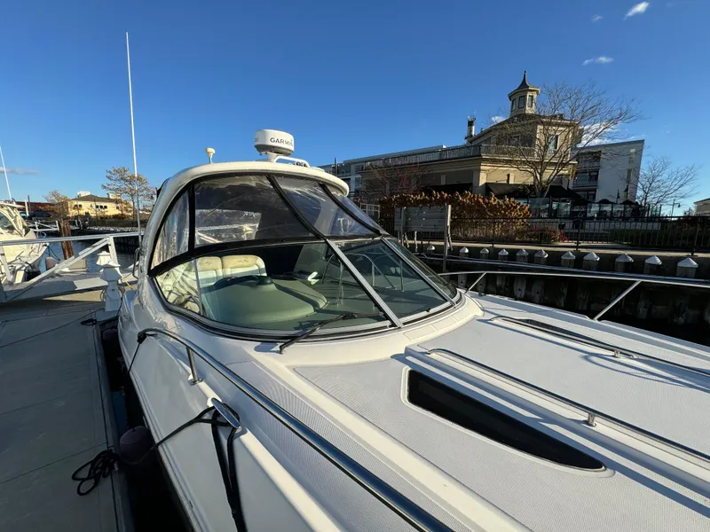 Slide: The Image of 2008 Sea Ray 310 Sundancer docked, showcasing sleek design and spacious cockpit under clear blue sky. - 4