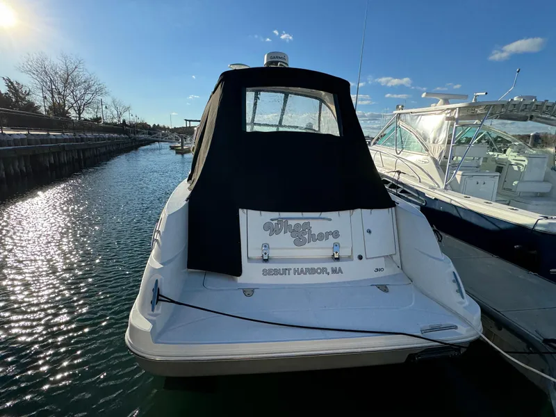 Slide: The Image of 2008 Sea Ray 310 Sundancer docked, rear view with black cover, sunny day. - 5