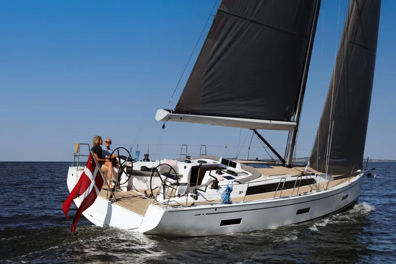 Slide: The Image of 2026 X-Yachts X4 3 sailing on open water with two people onboard. - 4