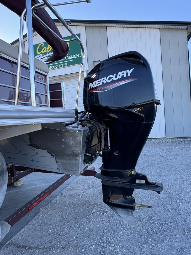 Slide: The Image of 2020 South Bay 521 CR boat with Mercury outboard motor, parked near a building. - 1