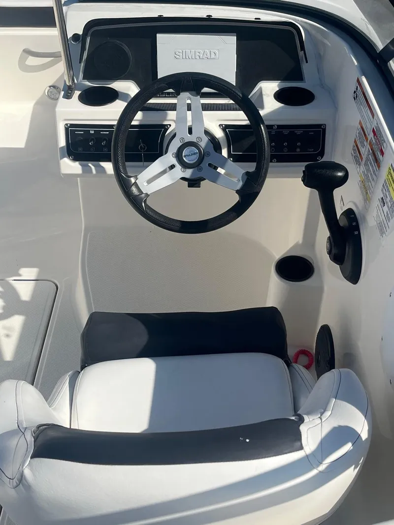 Slide: The Image of 2021 Bayliner DX 2200 boat cockpit with steering wheel and control panel. - 11