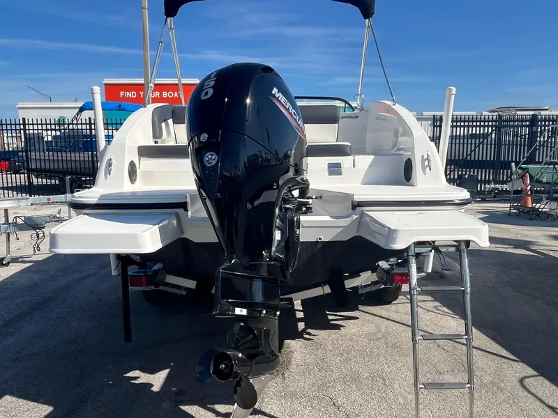 Slide: The Image of 2021 Bayliner DX 2200 boat with Mercury outboard motor, parked on a trailer. - 4