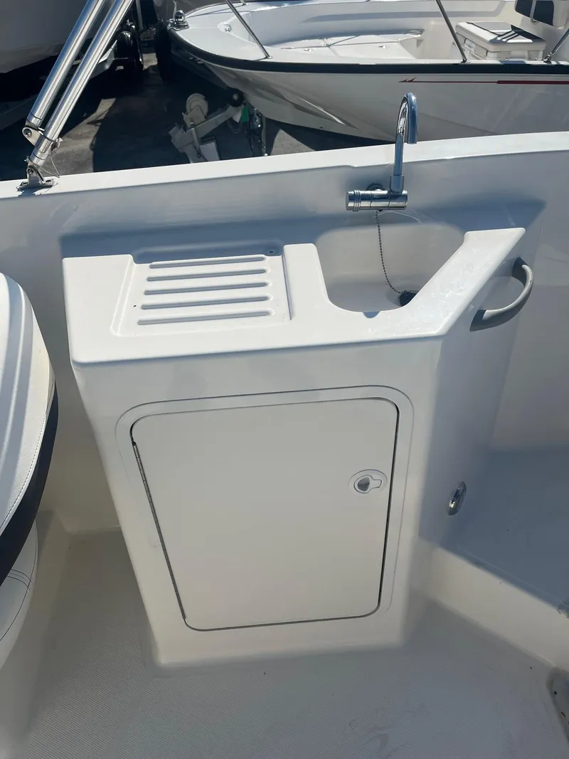 Slide: The Image of 2021 Bayliner DX 2200 boat sink and storage compartment. - 7