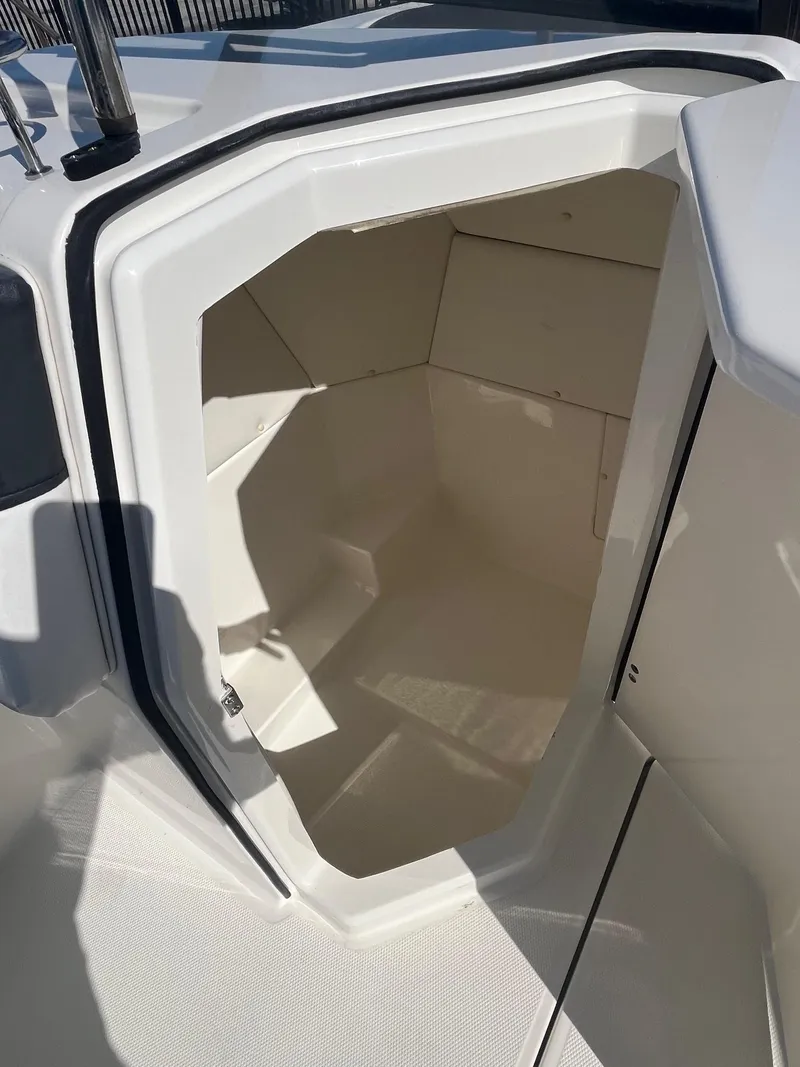 Slide: The Image of 2021 Bayliner DX 2200 boat storage compartment, open and empty, with white interior. - 9