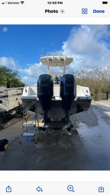 Slide: The Image of 2016 Sportsman HERITAGE 252 boat with dual engines, parked outdoors under a blue sky. - 4