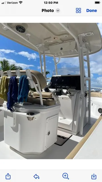 Slide: The Image of 2016 Sportsman HERITAGE 252 boat interior with helm and seating under clear blue sky. - 7