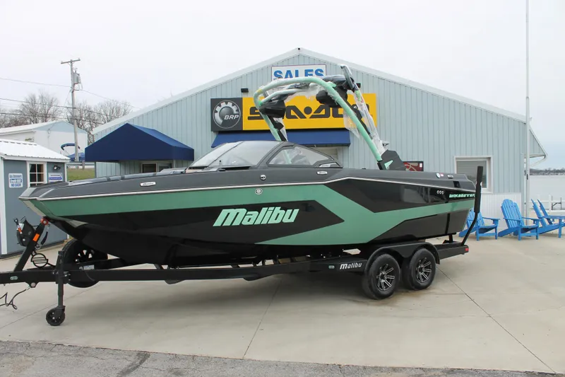 The Image of 2025 Malibu 23 MXZ boat on trailer outside sales building. - 0