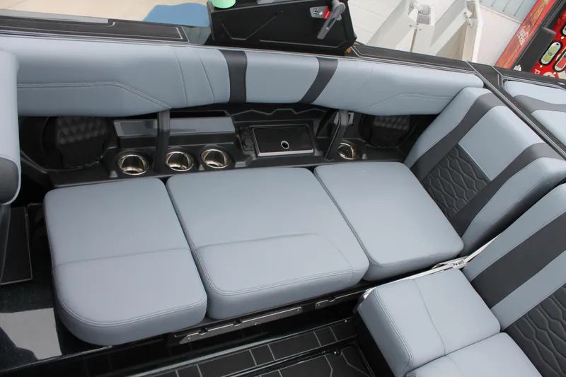 Slide: The Image of 2025 Malibu 23 MXZ boat interior with sleek gray seating and cup holders. - 4