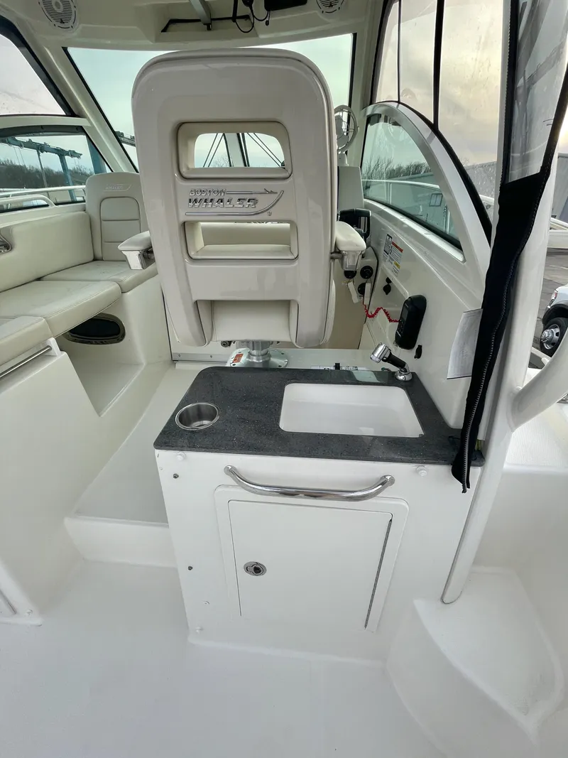 Slide: The Image of Interior of 2022 Boston Whaler 285 Conquest boat, featuring seating and compact sink area. - 11