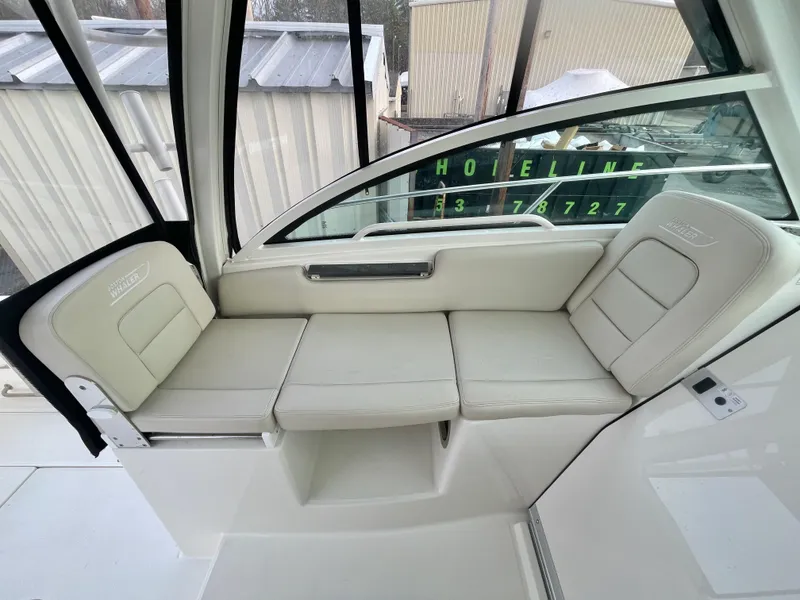 Slide: The Image of 2022 Boston Whaler 285 Conquest interior seating area with beige upholstery. - 15
