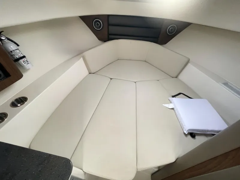 Slide: The Image of 2022 Boston Whaler 285 Conquest cabin interior with beige seating and storage compartments. - 19