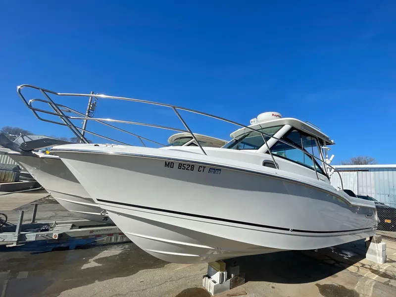 Slide: The Image of 2022 Boston Whaler 285 Conquest boat on display under clear blue sky. - 2